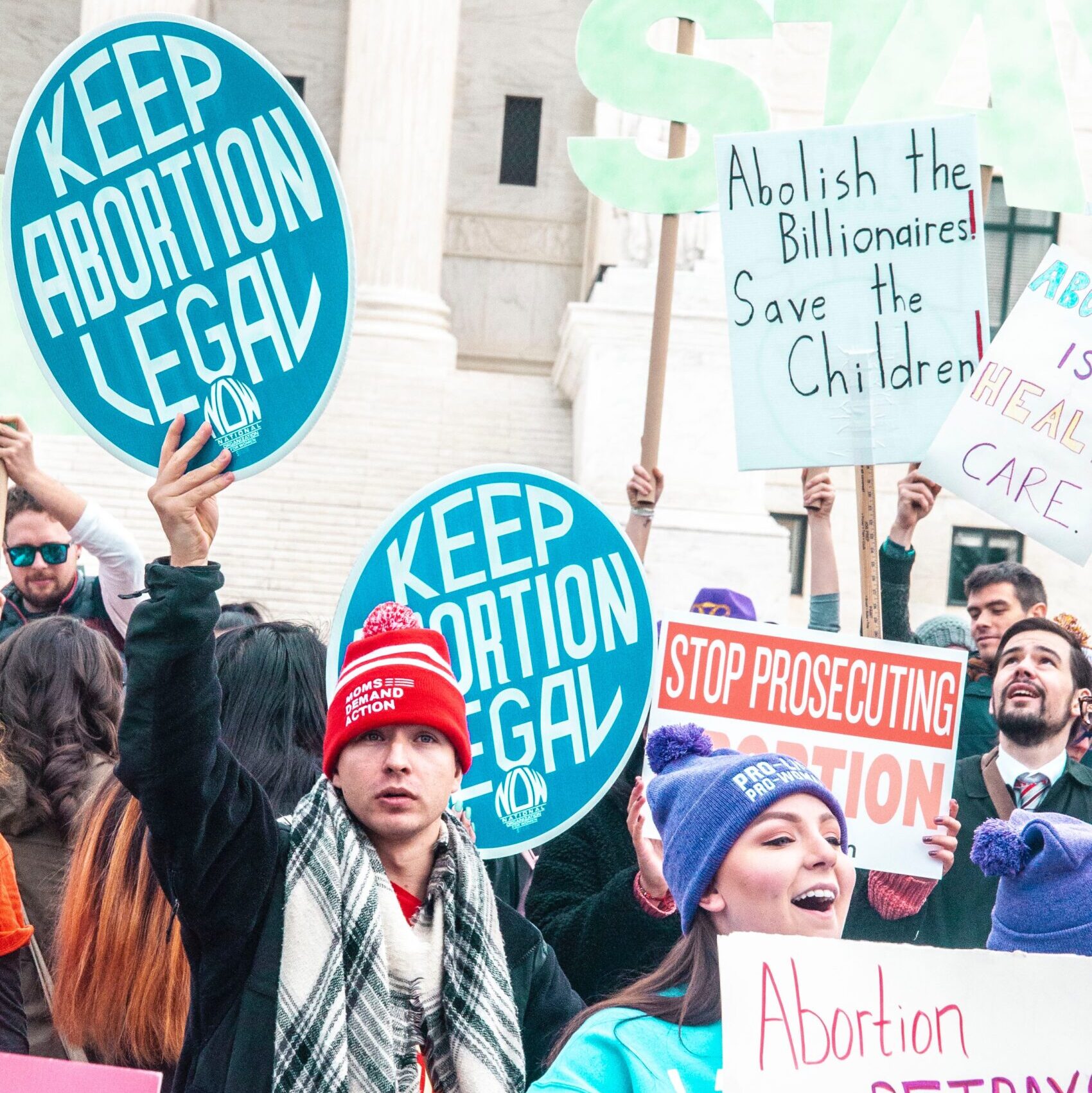 people holding blue and red signage
